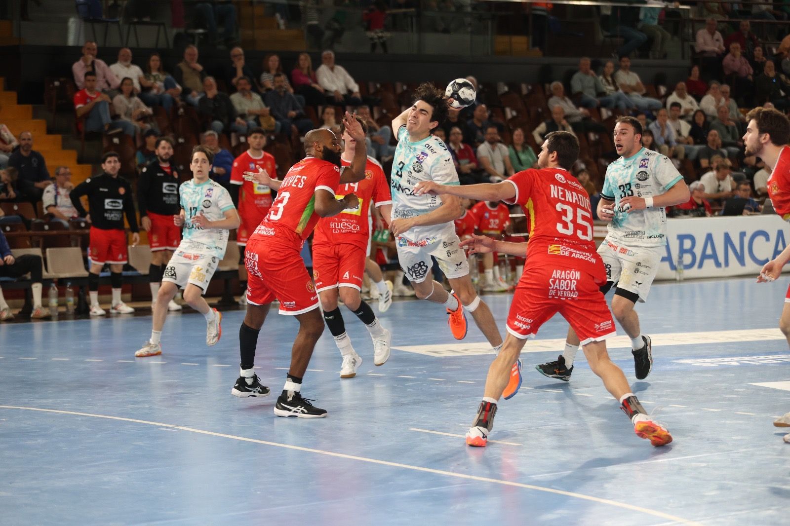 El central del Ademar, Miñambres, se cuela para lanzar entre los defensores del Huesca. | FERNANDO OTERO El central del Ademar, Miñambres, se cuela para lanzar entre los defensores del Huesca. | FERNANDO OTERO