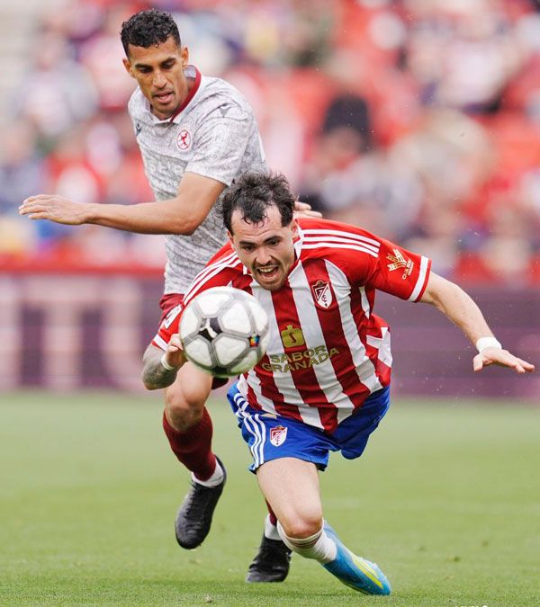 Víctor García pelea por un balón con el atacante del Granada cayéndose. | LA LIGA Víctor García pelea por un balón con el atacante del Granada cayéndose. | LA LIGA