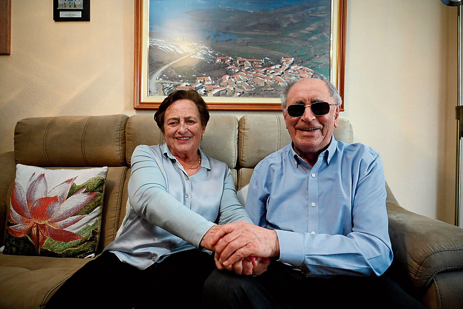Sara e Isidro, de la mano, en sus bodas de platino, y con su añorado Lodares presidiendo sus recuerdos de ‘alrededor’ de sus 90 años, de granito. | SAÚL ARÉN