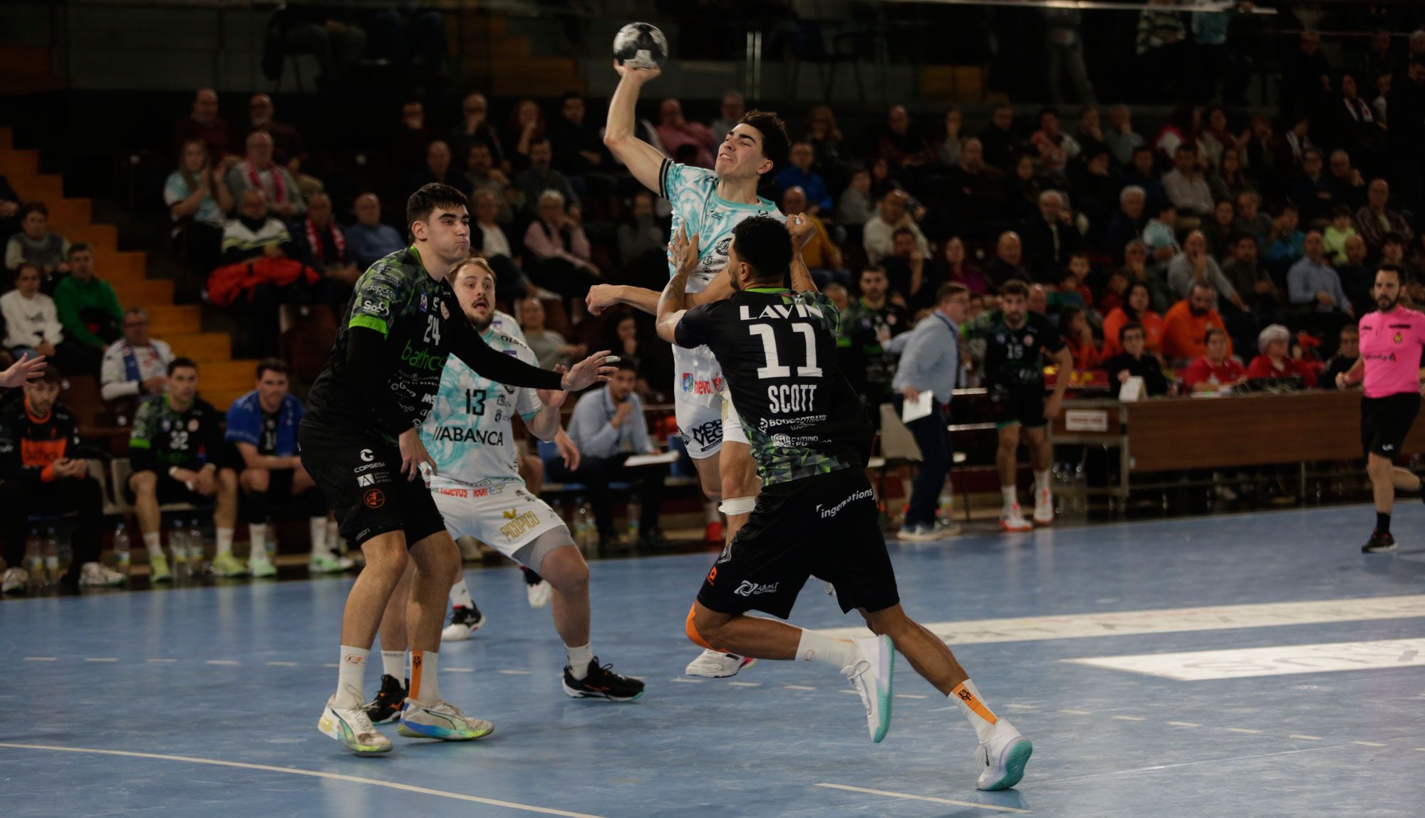 El central del Ademar, Miñambres, lanza ante la defensa de Scott durante el encuentro frente alTorrelavega en el Palacio. FERNANDO OTERO