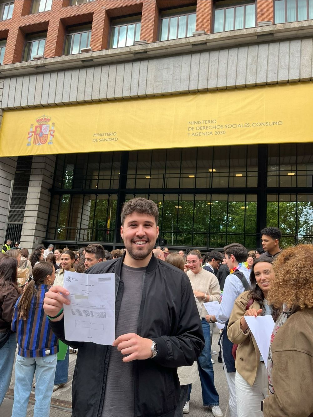 David Pastor, con el documento de elección MIR en la mano, posa a las puertas del Ministerio de Sanidad tras convertirse en el primer residente de Medicina de Urgencias y Emergencias de España.