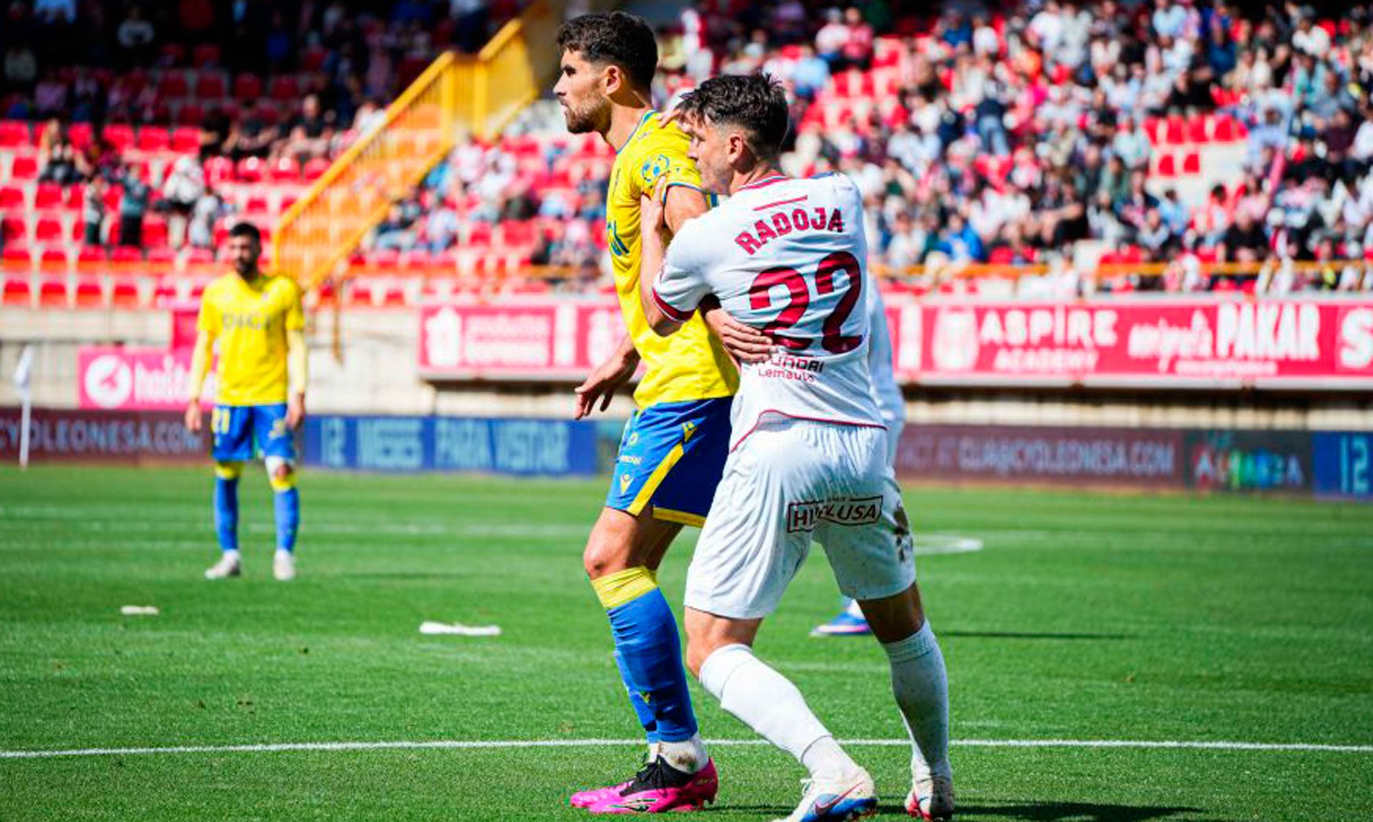 El mediocentro de la Cultural, Radoja, defiende a un jugador del Cádiz. | LALIGA
