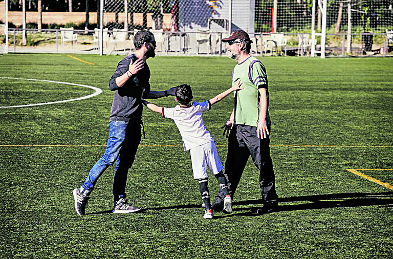 Un niño separa a dos adultos en una discusión durante un partido de fútbol. |LNC
