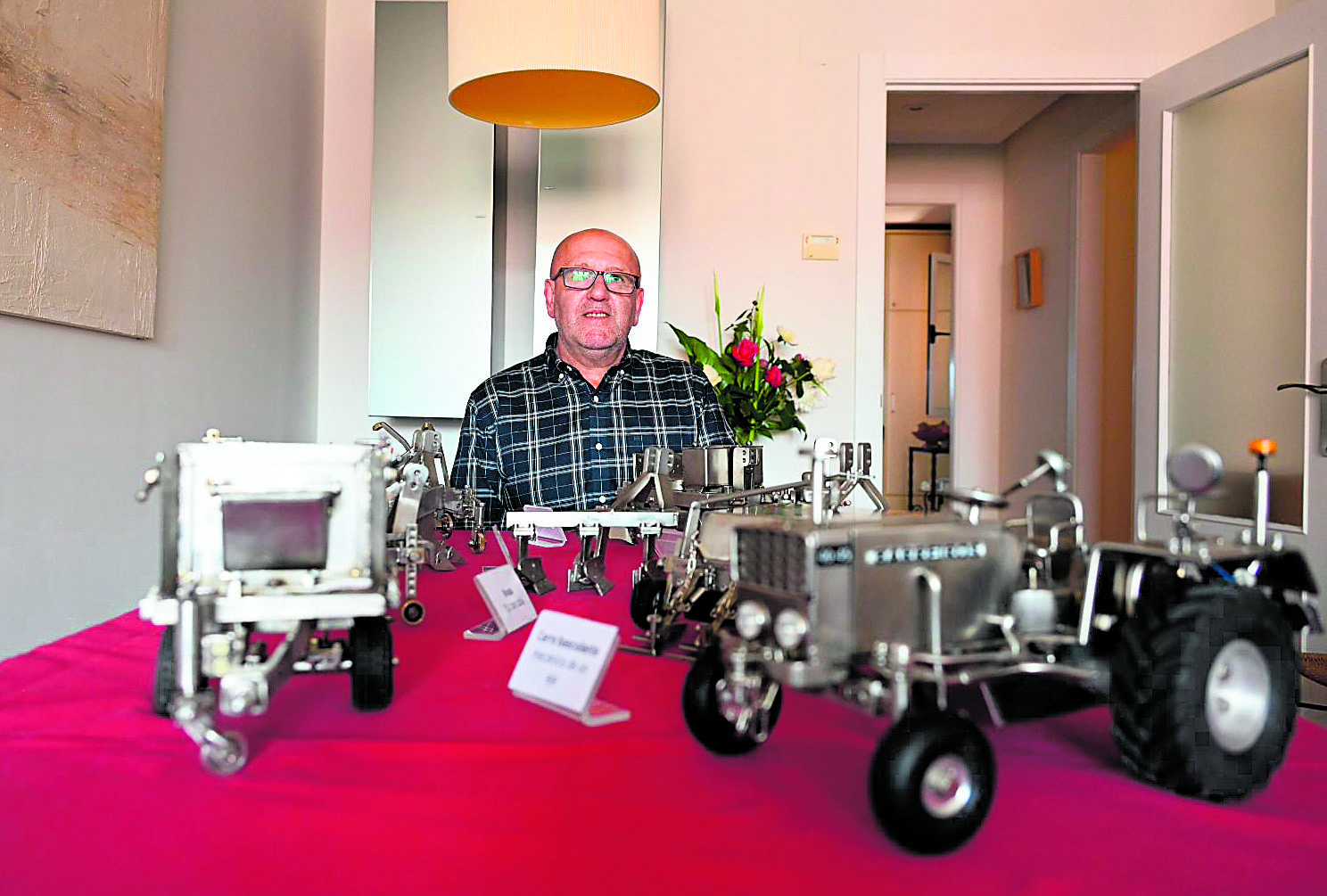 Tino Benavides delante de algunas de sus creaciones, en primer plano la recreación del primer tractor de su padre, un histórico Barreiros. | SAÚL ARÉN 