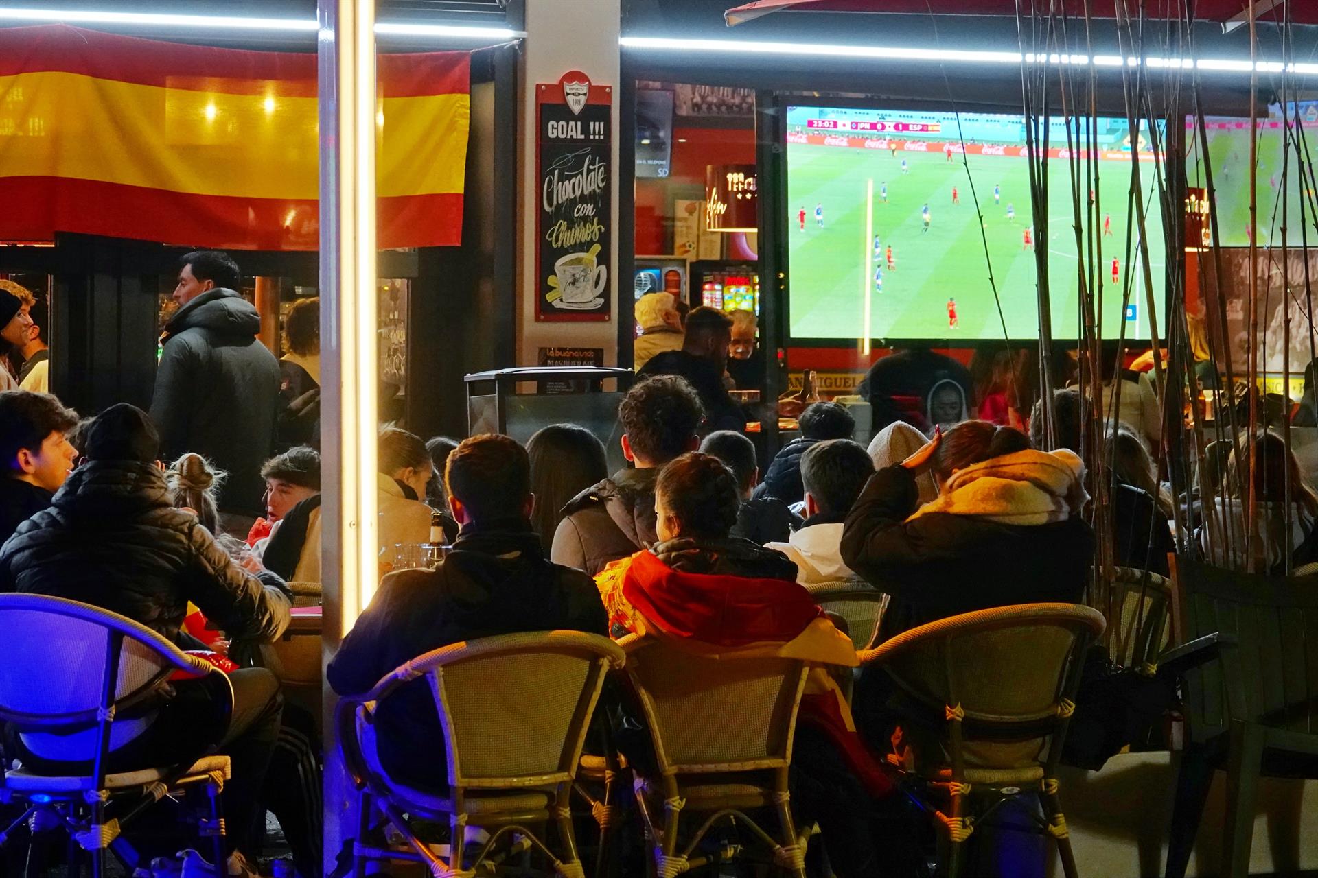 Varios aficionados ven en una pantalla de un bar el partido de fútbol entre España y Japón, durante el Mundial de Qatar 2022. | XUAN CUETO (Europa Press)