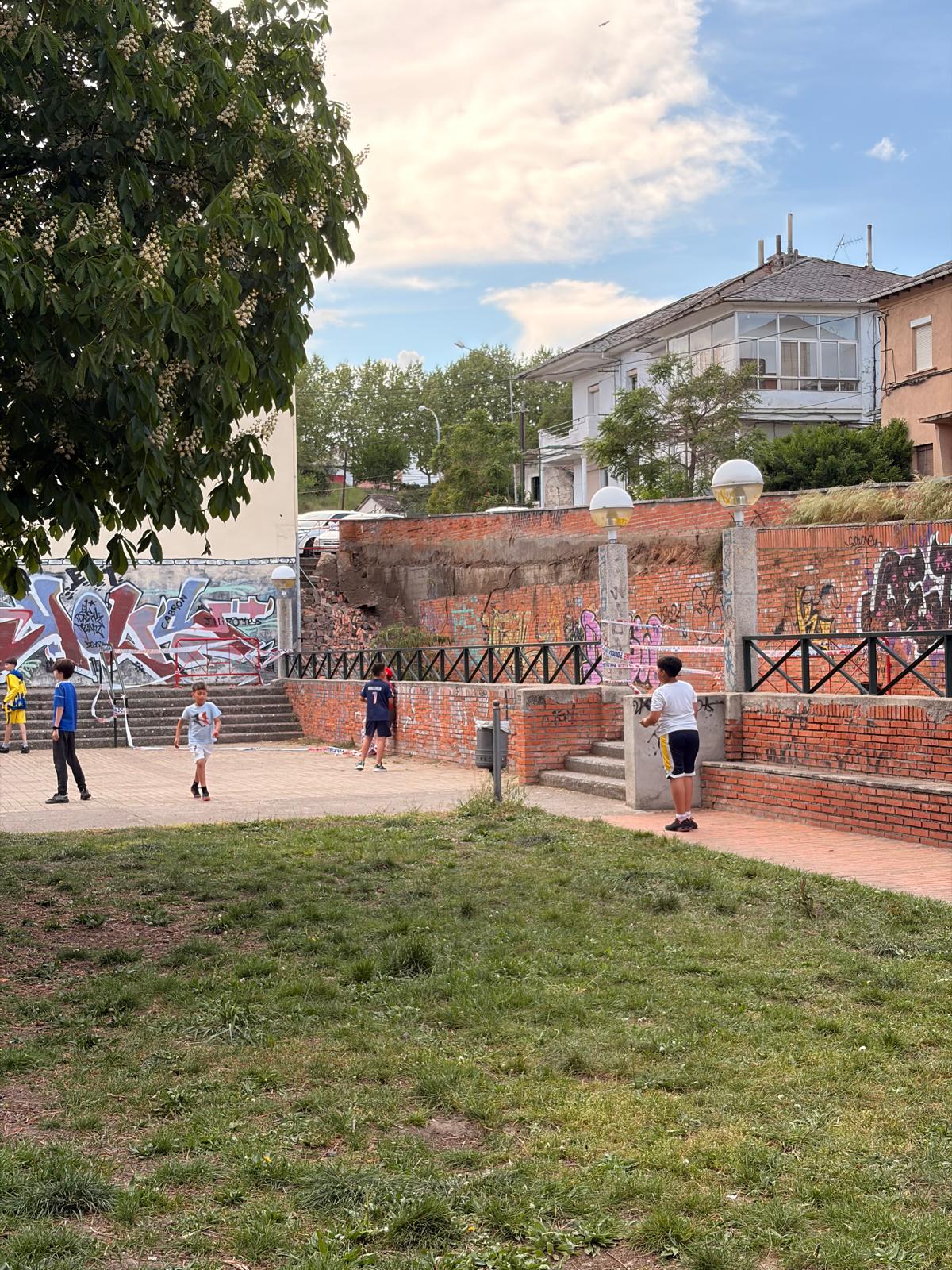 Zona en la que se cayó el muro y sigue sin repararse, con los niños cerca.