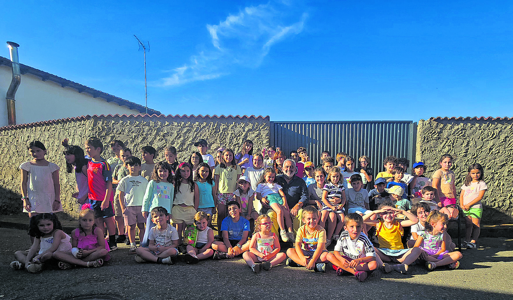 Foto de familia de los sesenta niños que este año participaron en el Concurso de Pintura al Aire Libre e Infantil de Villamondrín de Rueda... con Villa.