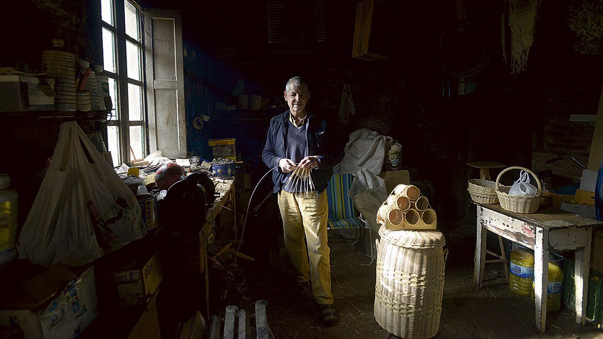 José Mari, ‘el cestero’ de Corniero, rodeado de algunas de las piezas que crea:papeleras, cestas de todos los tamaños, sonajeros. | MAURICIO PEÑA