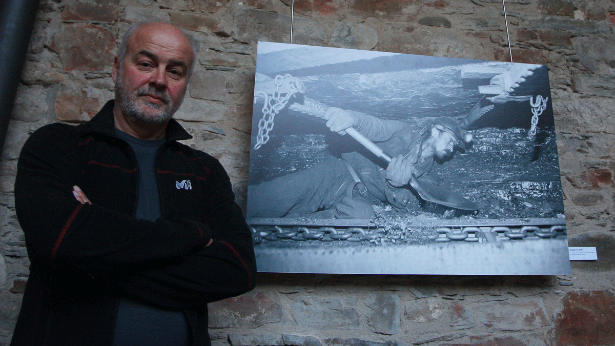 Mauricio Peña frente a la fotografía de un minero en la explotación de carbón Antracitas Gaiztarro en el año 1993. | César Sánchez