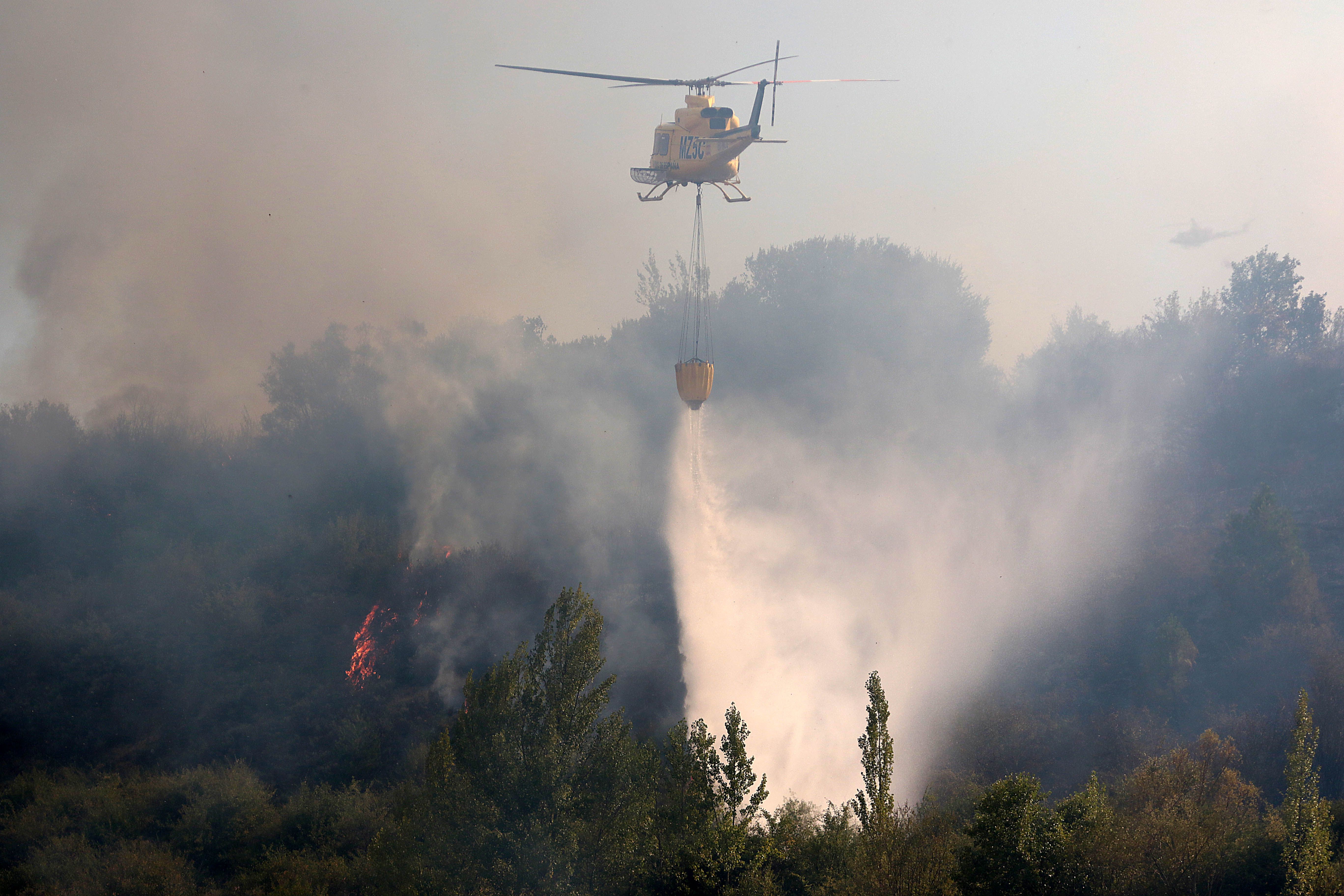 Un helicóptero lucha contra el incendio forestal de Cifuentes de Rueda este lunes, ya estabilizado. | PEIO GARCÍA (ICAL)
