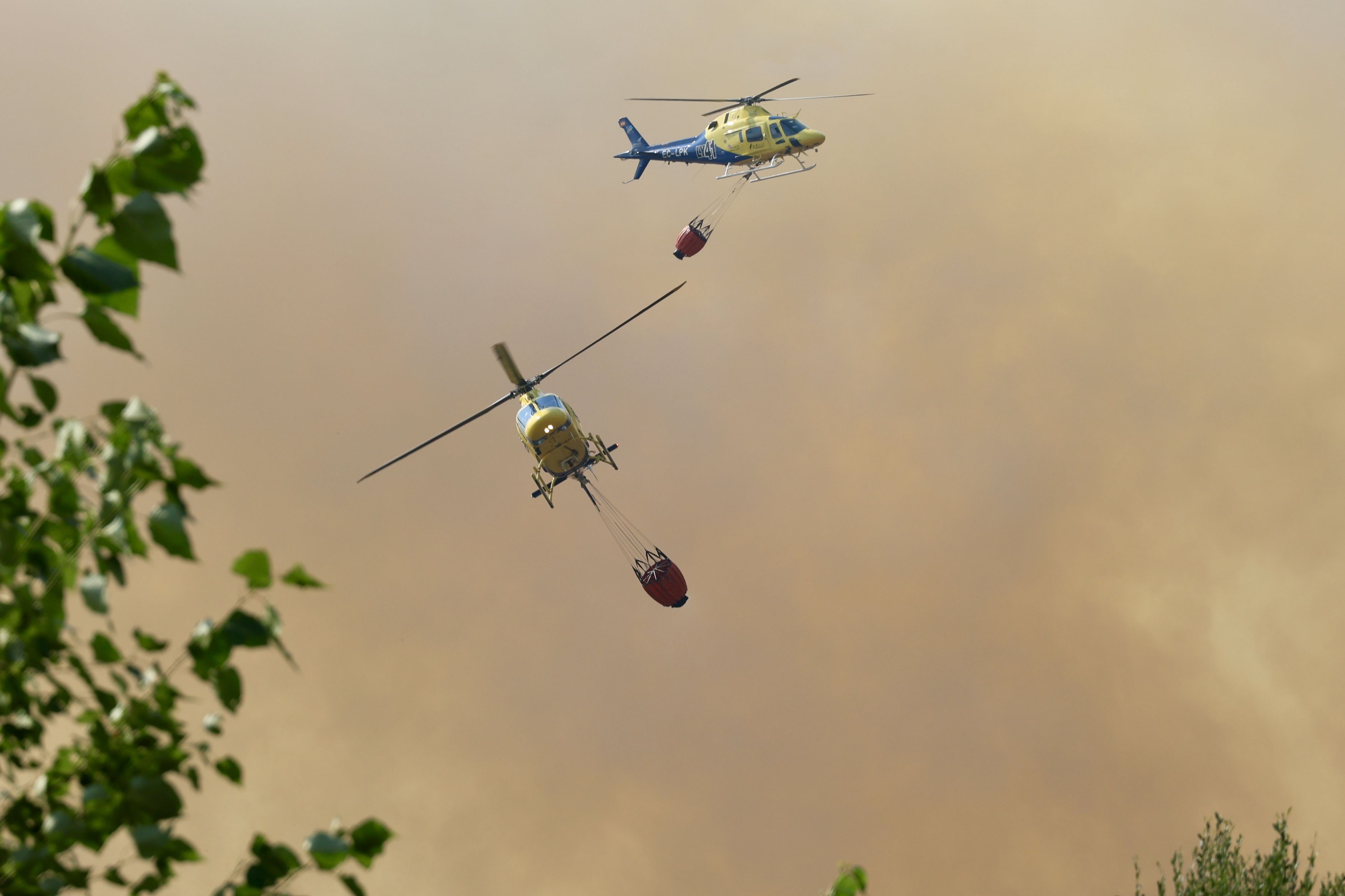 Dos helicópteros trabajan para sofocar un incendio forestal. | CARLOS S. CAMPILLO (ICAL)