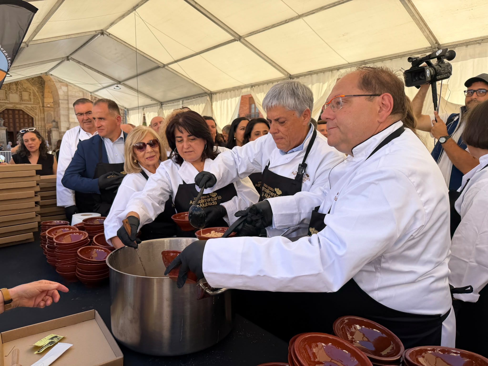 Medio centenar de voluntarios volvió satisfacer los paladares del numeroso público congregado en la Plaza Mayor de La Bañeza para la gran Alubiada. | SAÚL ARÉN