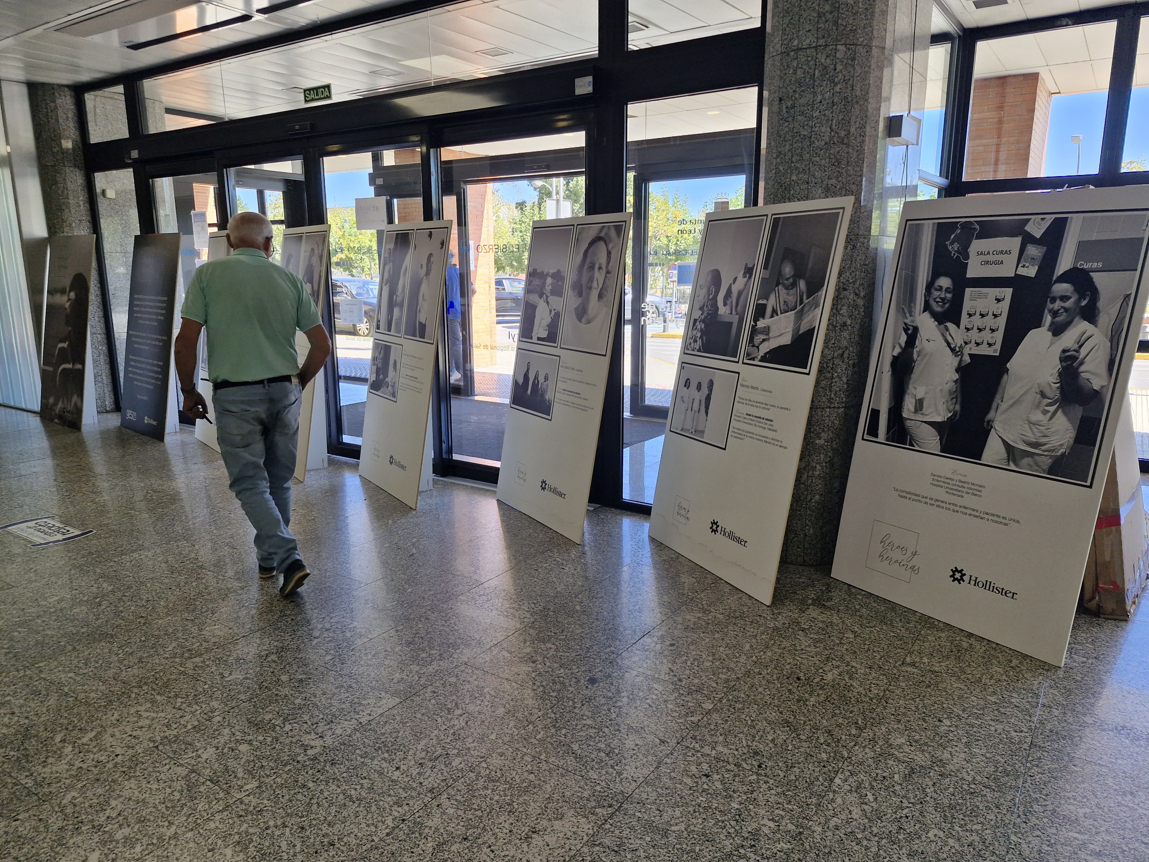 Una persona observa la exposición 'Héroes y Heroínas' en el vestíbulo principal del Hospital El Bierzo.