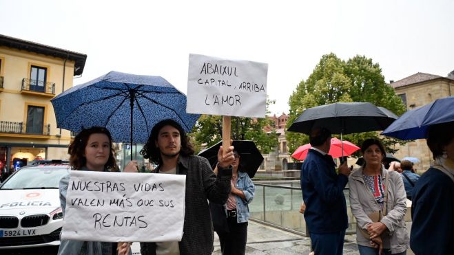 Varios manifestantes portan carteles contra la situación de la vivienda. | SAÚL ARÉN