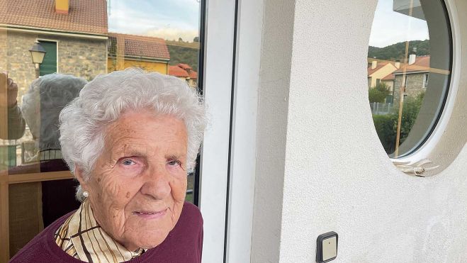 La casi centenaria a la puerta de su casa en la que se reflejan otras del nuevo pueblo La casi centenaria a la puerta de su casa en la que se reflejan otras del nuevo pueblo