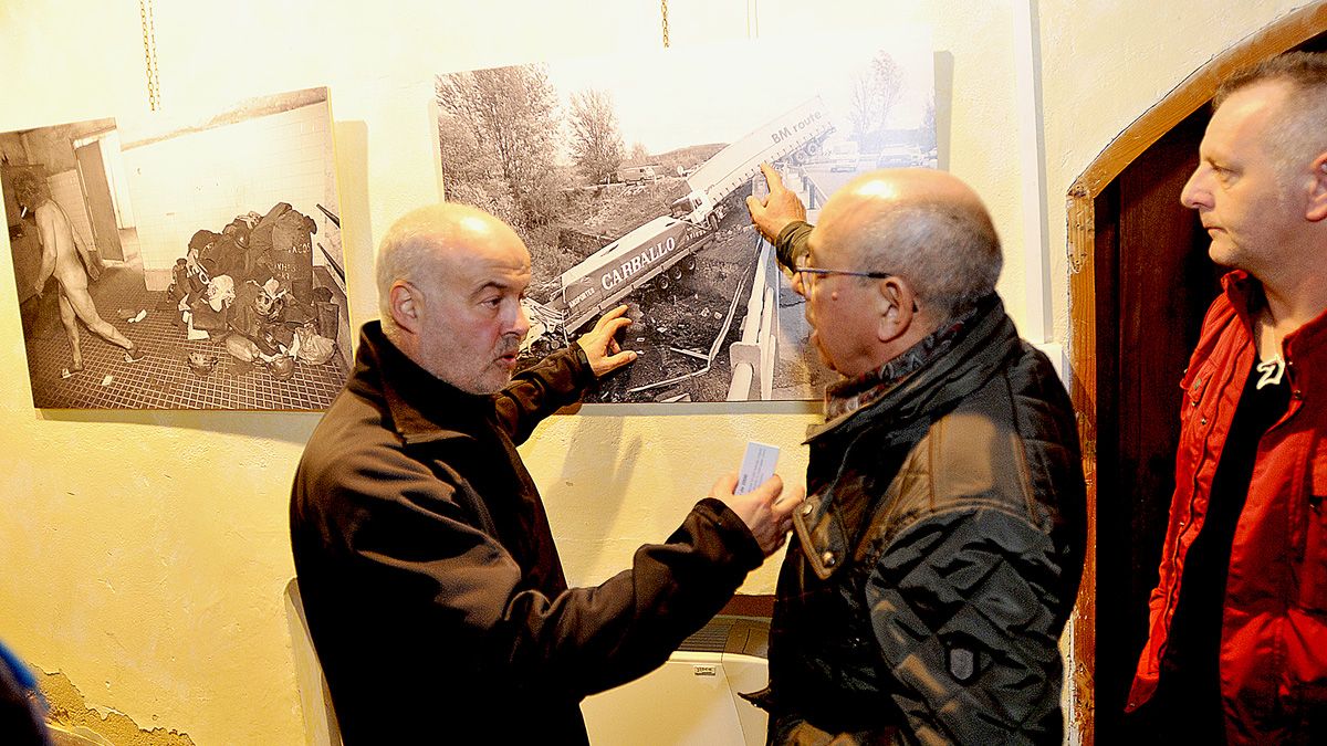 El fotógrafo Mauricio Peña muestra al alcalde de Mansilla una de las fotografías de la exposición. | DANIEL MARTÍN