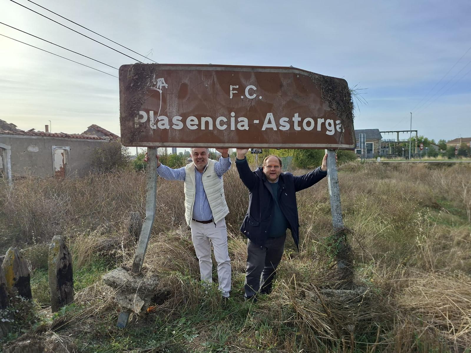 José Luis Nieto y Javier Carrera junto a uno de los antiguos carteles ferroviarios de la ruta. | L.N.C.