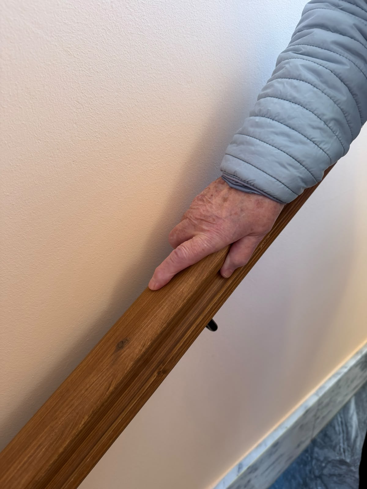 Aurora, vecina de Boñar de 89 años, se apoya en la nueva barandilla instalada en las escaleras de su edificio