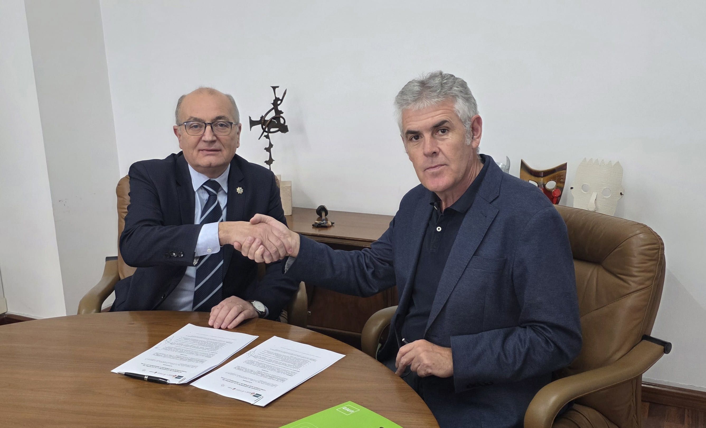 Firma del acuerdo entre José Antonio Cuba Cal (i) y Jorge Vega Núñez (d).