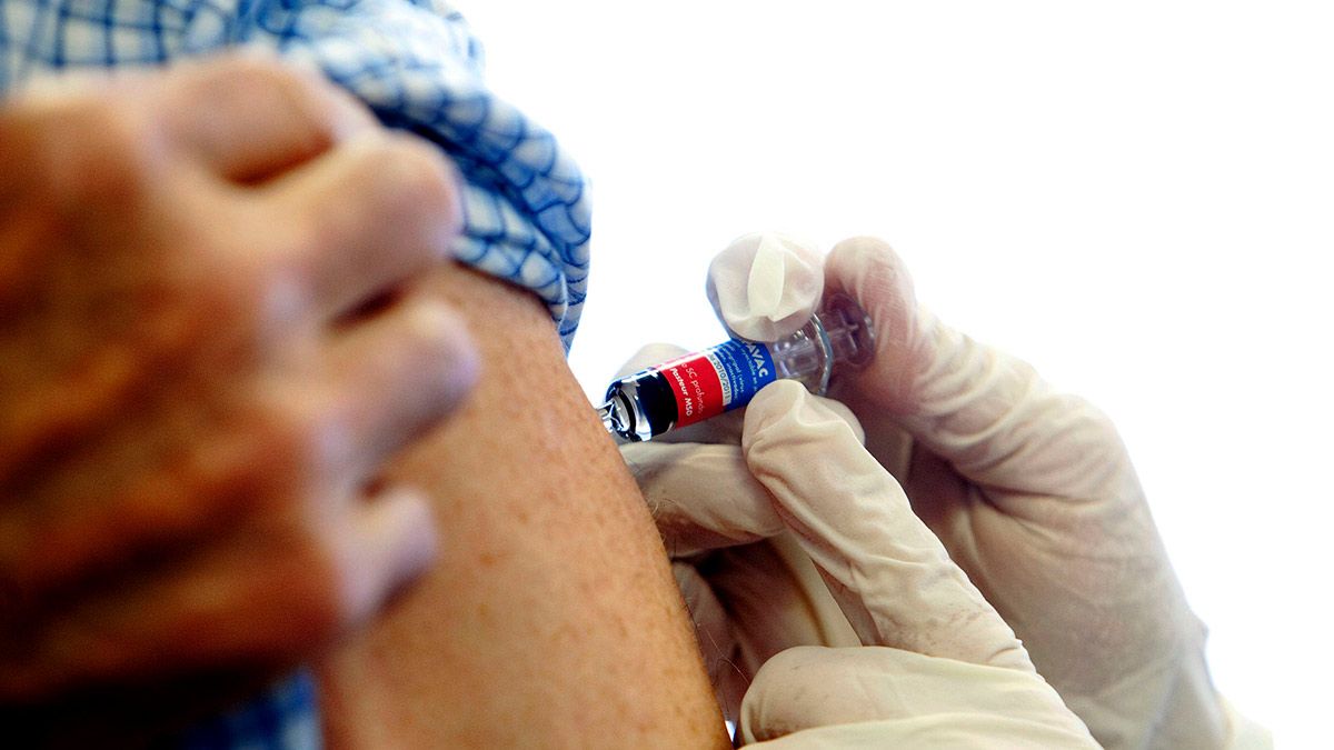 Una enfermera administra la vacuna de la gripe.