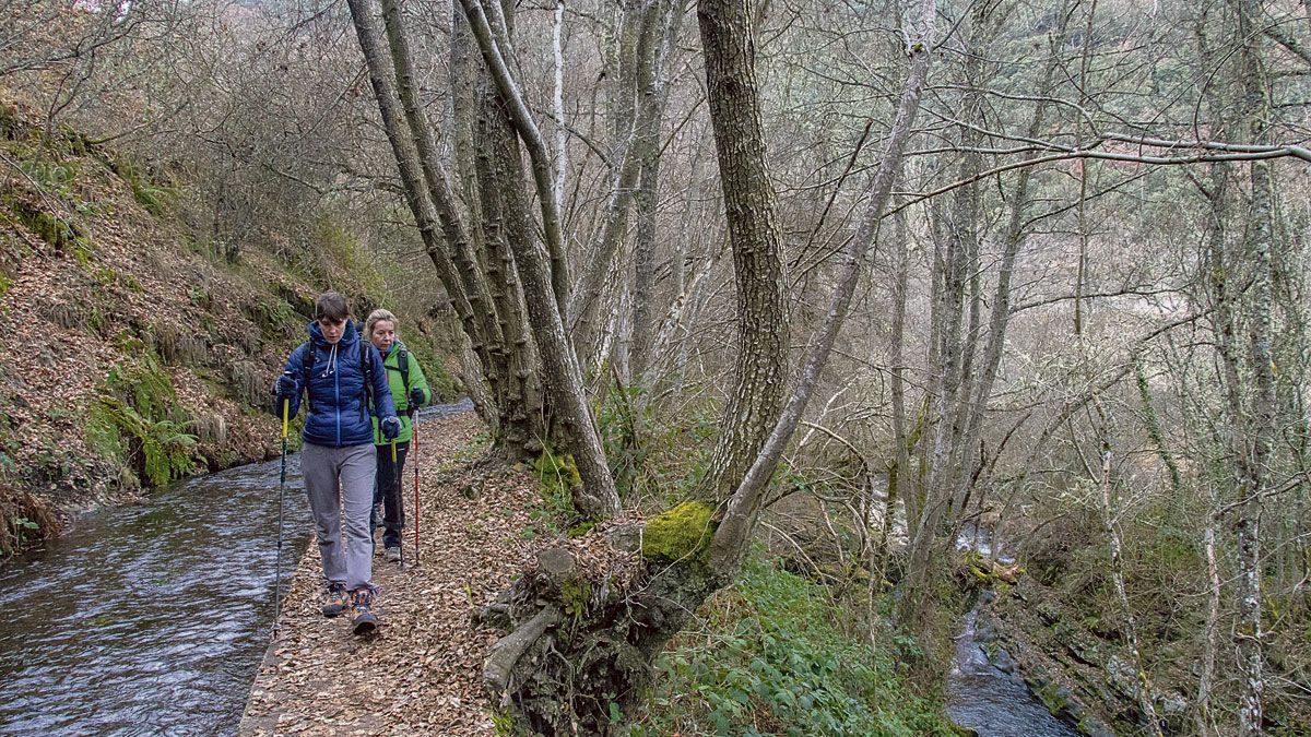 Dos excursionistas recorren la acequia junto al río. | VICENTE GARCÍA