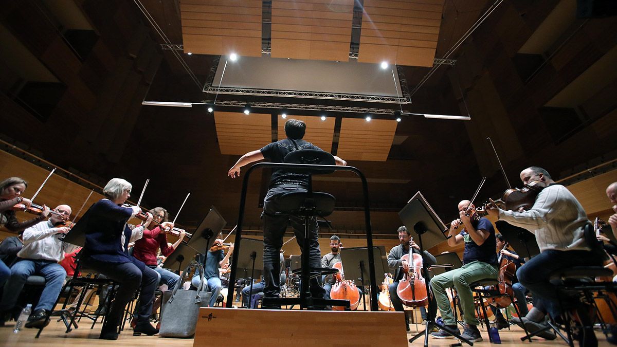 El director de orquesta castellonense Sergio Alapont (de espaldas), toma la batuta de la Orquesta Sinfónica de Castilla y León durante un ensayo. | IMÁGENES: MIRIAM CHACÓN (ICAL)
