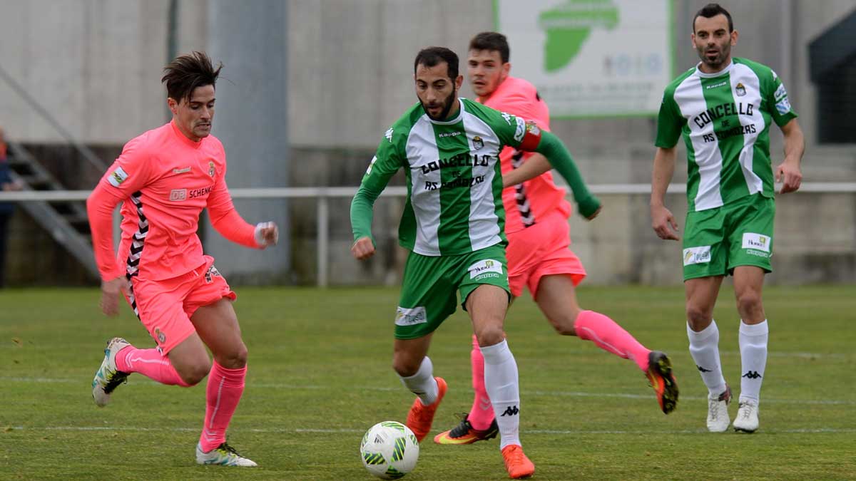 Ortí intenta recuperar el balón que conduce un jugador del Somozas, con Gallar al fondo. | DANIEL ALEXANDRE (DIARIO DE FERROL)