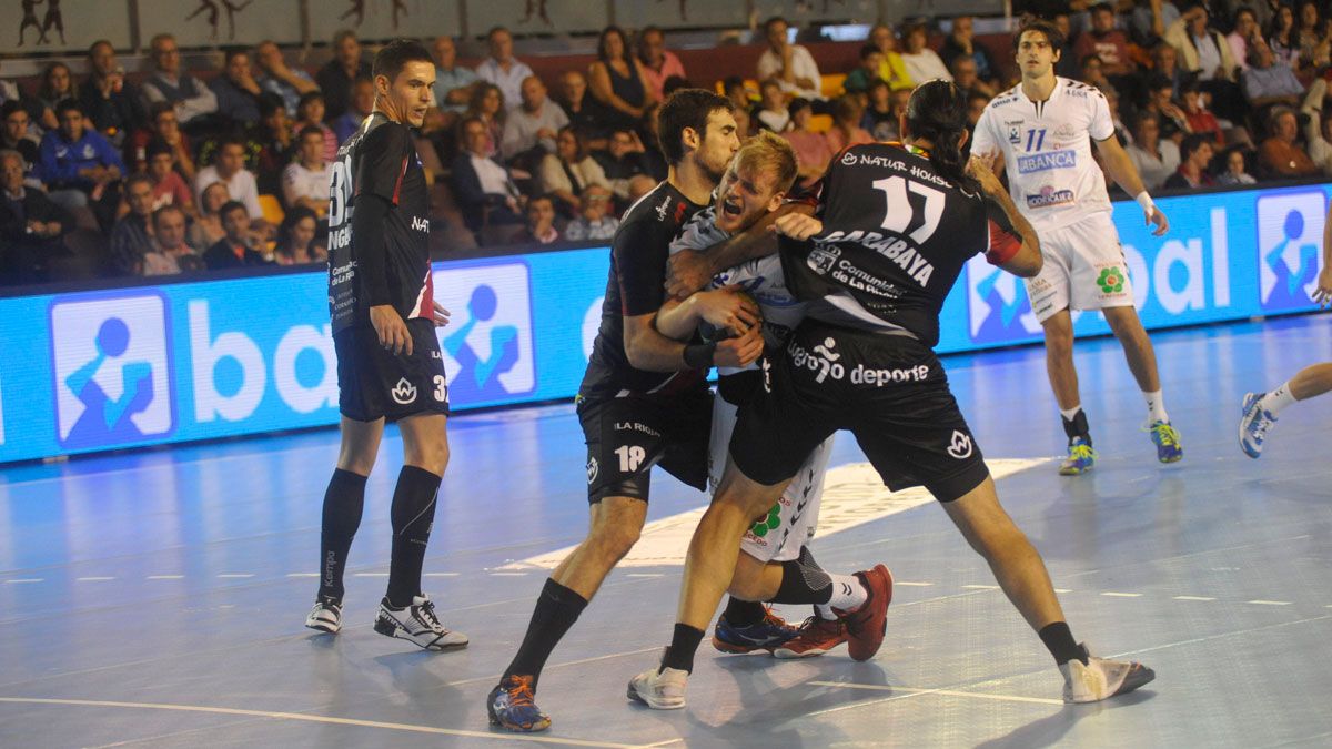 Piñeiro es sujetado por Garabaya y Carlos Molina en el partido de ida en elPalacio. | DANIEL MARTÍN