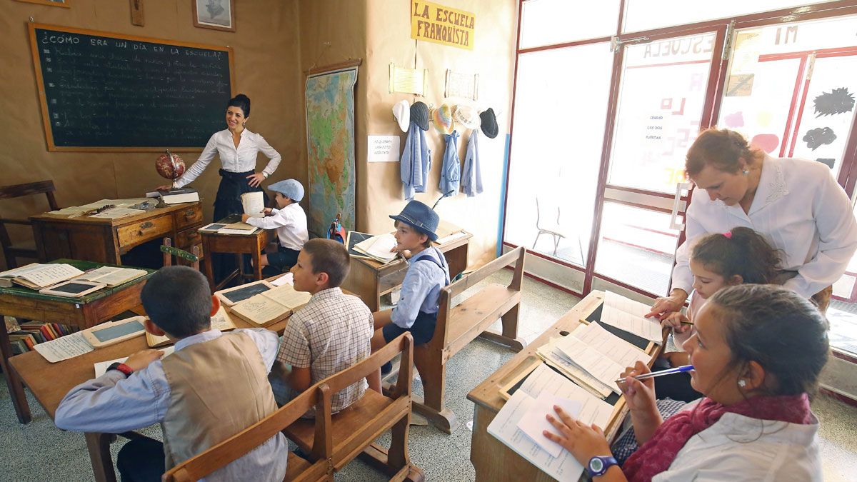 Niños y maestros, vestidos de época y en un ambiente que recuerda a la escuela de antaño. | César Sánchez