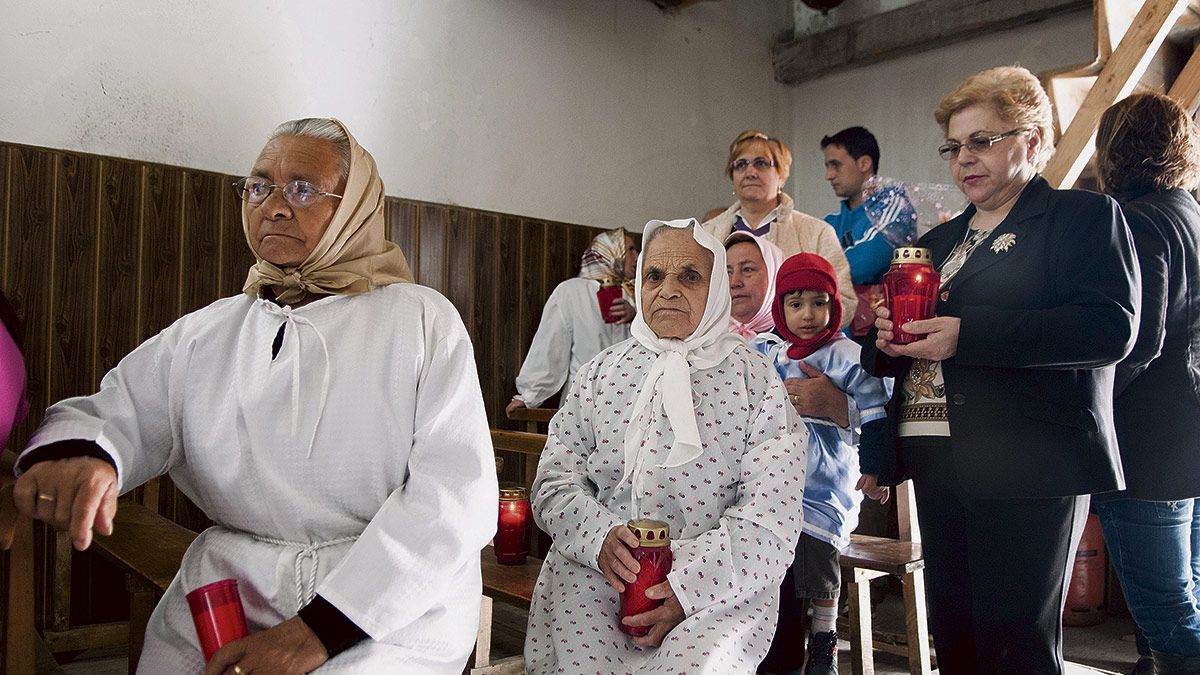 Las amortajadas se visten en el interior de la iglesia con sus mortajas antes de dar comienzo la procesión por las calles de Quintana Fuseros. | MAURICIO PEÑA