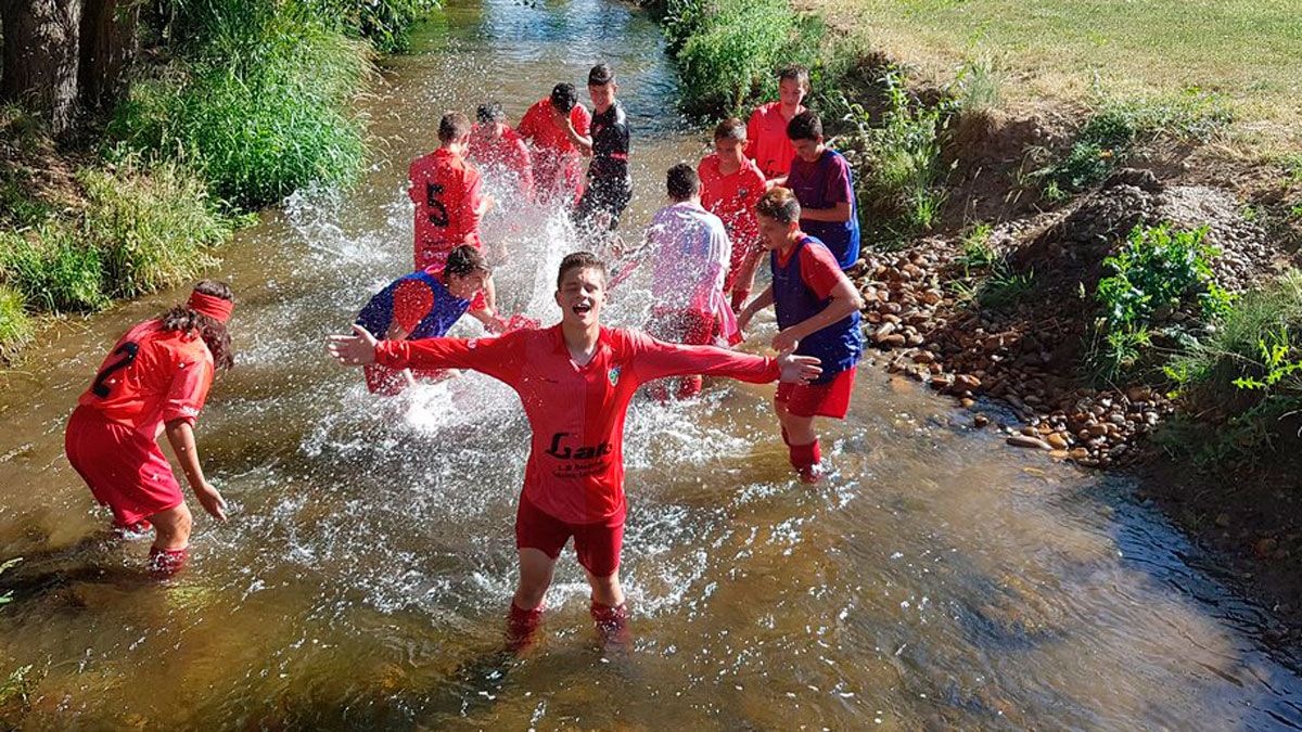 Los jugadores del Veguellina festejan en el río el ascenso. | @VEGUELLINACF