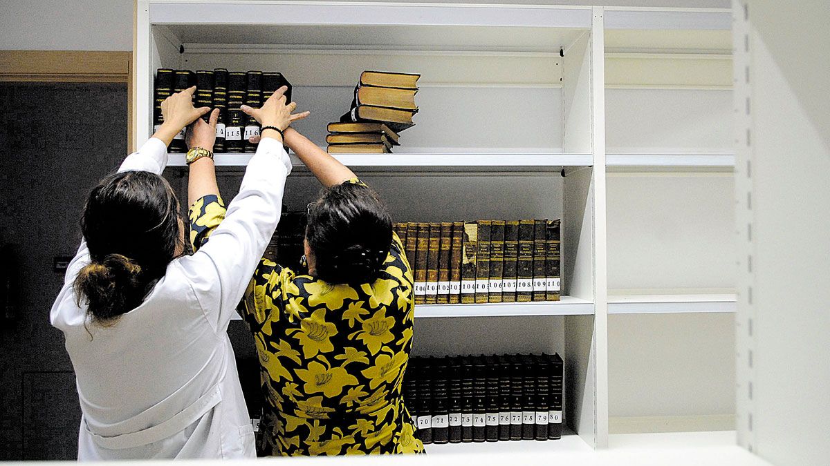 Dos trabajadoras trasladan documentos en un servicio municipal del Ayuntamiento de León. | MAURICIO PEÑA