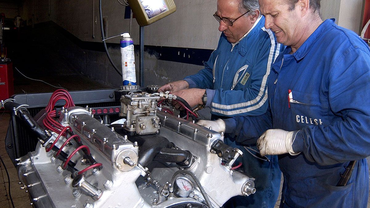 Dos mecánicos inspección el motor de un vehículo en su taller de reparaciones. | L.N.C.
