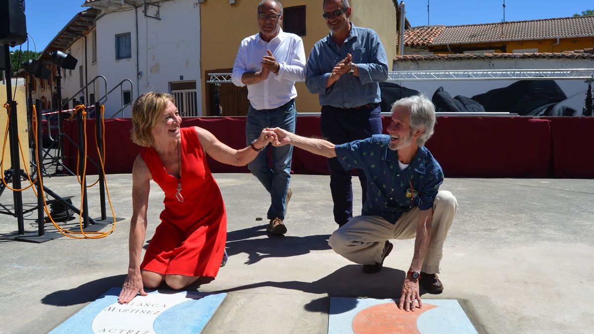 Los actores Blanca Martínez y Mario Pardo sobre sus placas, situadas en la Plaza Elena Santiago de Veguellina. | P. FERRERO