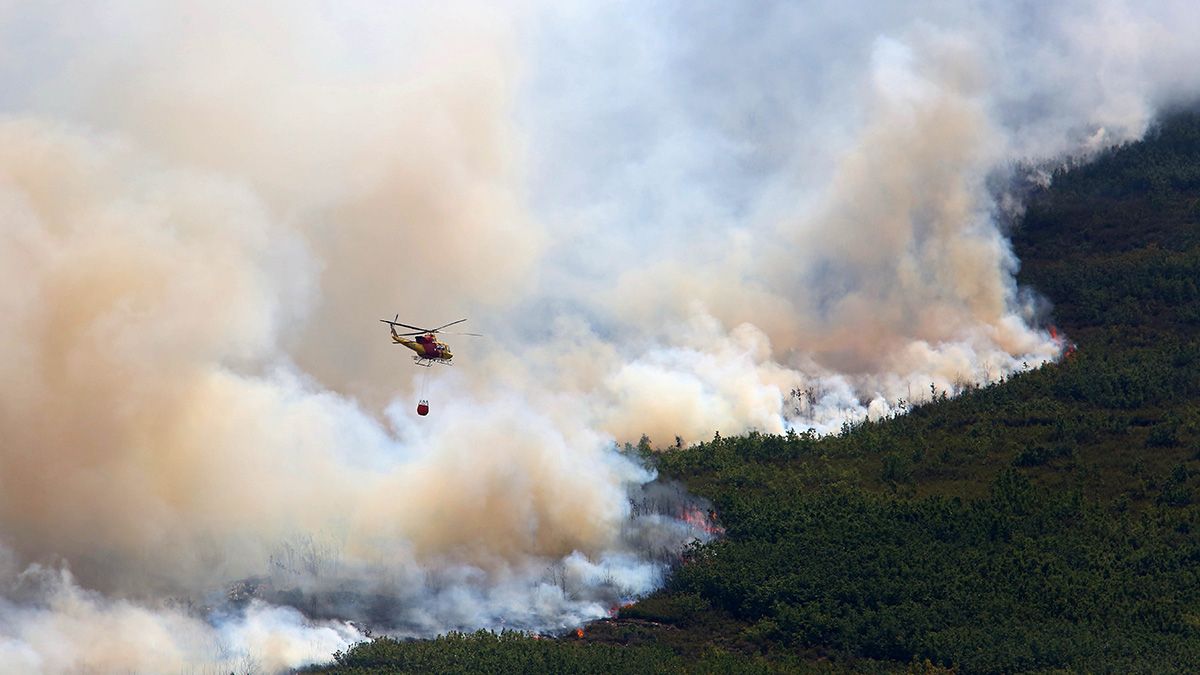 Un helicóptero trabaja en la extinción del incendio. | CÉSAR SÁNCHEZ