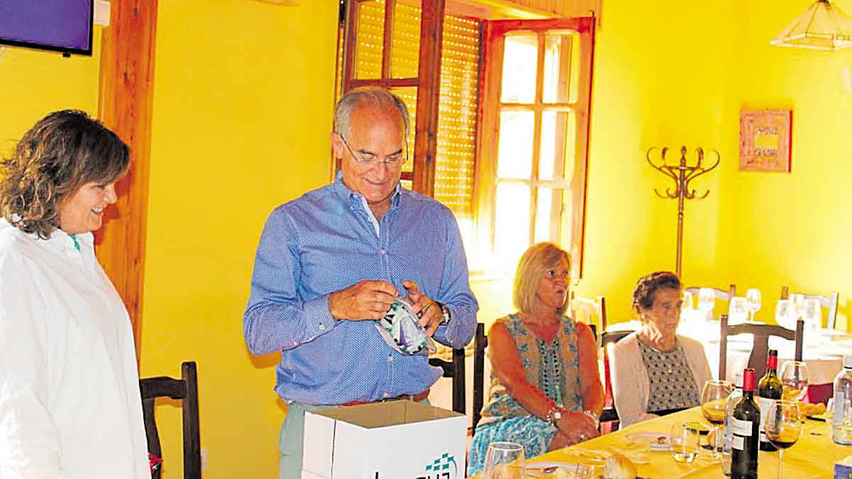 El profesor abre un regalo rodeado de la directora y su familia. | CELIA FRANCISCO