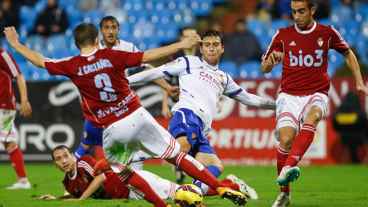 Castañeda y Alberto Aguilar tratan de taponar un disparo en el partido disputado frente al Zaragoza en la primera vuelta. | EL PERIÓDICO DE ARAGÓN