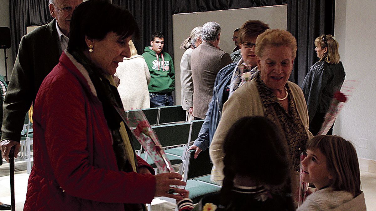 Imagen de la entrega de claveles a las asistentes después de terminar el ‘Encuentro de la Mujer Rural del Órbigo’.