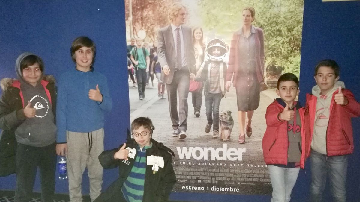 En el centro, Adrián Fanegas, rodeado de algunos de sus amigos, junto al cartel de la película ‘Wonder’. | ALFONSO FANEGAS