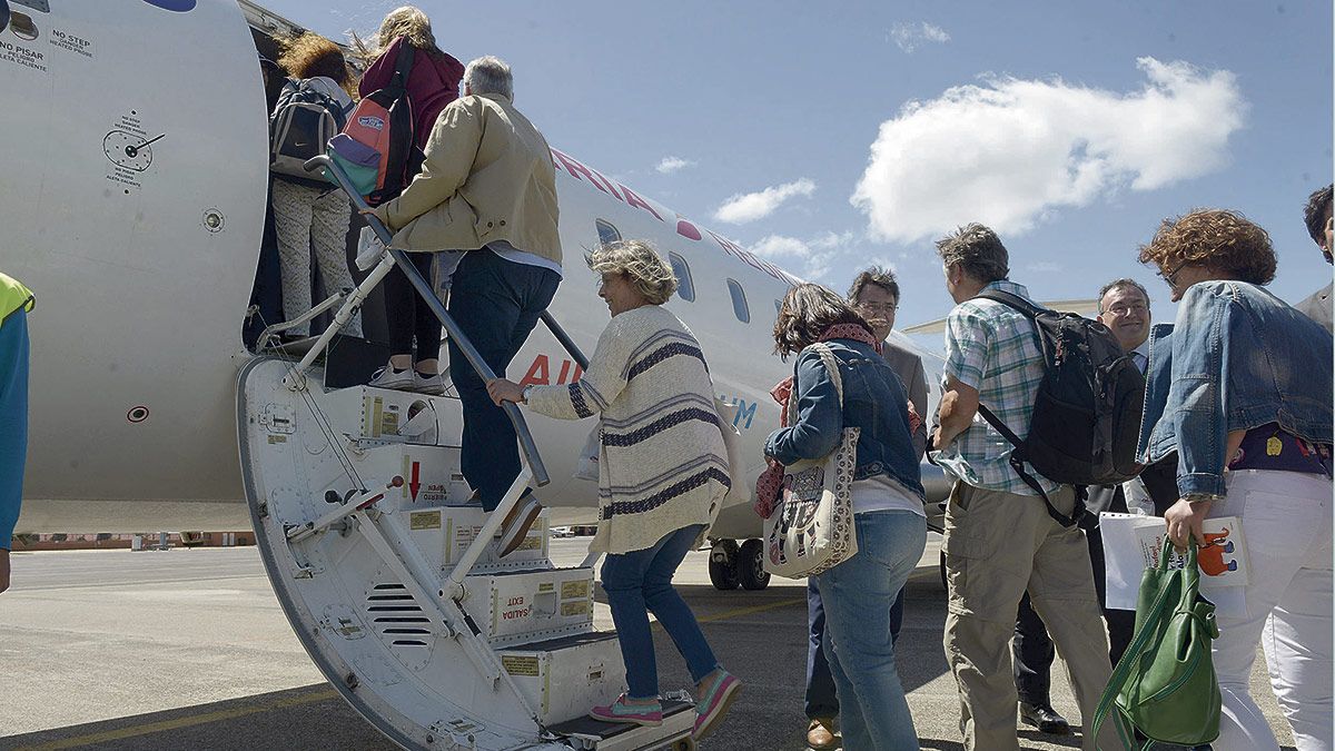 El presidente de la Diputación, Juan Martínez Majo, y el teniente alcalde de León, Fernando Salguero, saludan a los viajeros del primer vuelo estival. | MAURICIO PEÑA