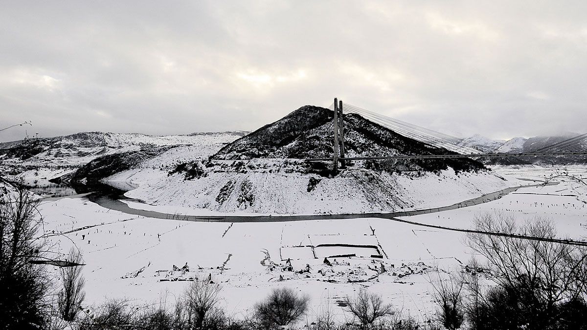 La nieve circunda y cubre el embalse de Los Barrios de Luna, el que más ha acusado la sequía en la provincia. | DANIEL MARTÍN