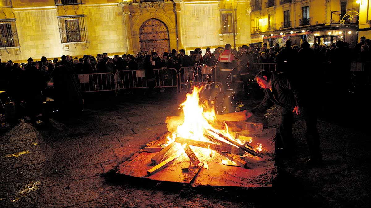 La hoguera de San Antón en una de las ediciones anteriores y en el recuadro el ‘coplero’ , Antón Llamas. | DANIEL MARTÍN