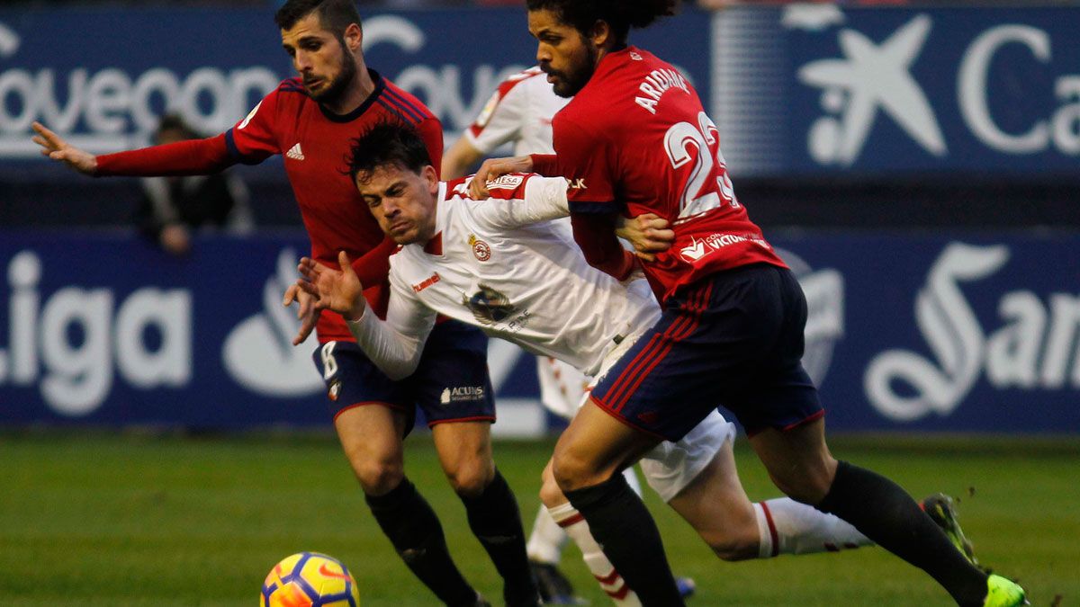 Guarrotxena es derribado por dos jugadores del Osasuna. | SANTIAGO ZUZA (DIARIO DE NAVARRA)