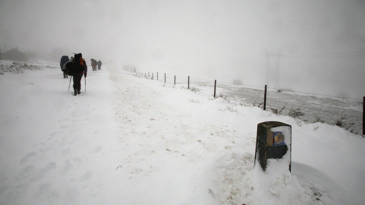 Un grupo de peregrinos intenta llegar a lo alto de la Cruz de Hierro, en Foncebadón, en la provincia leonesa.  | ICAL