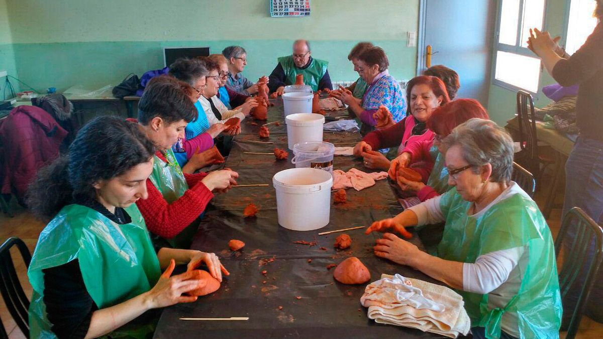 Asistentes al taller elaborando recipientes de barro con sus manos. | L.N.C.
