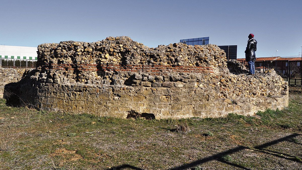 Uno de los visitantes observa la cabecera del templo, con mampostería en la que alternan ladrillo y llagueado. | D.G. LÓPEZ