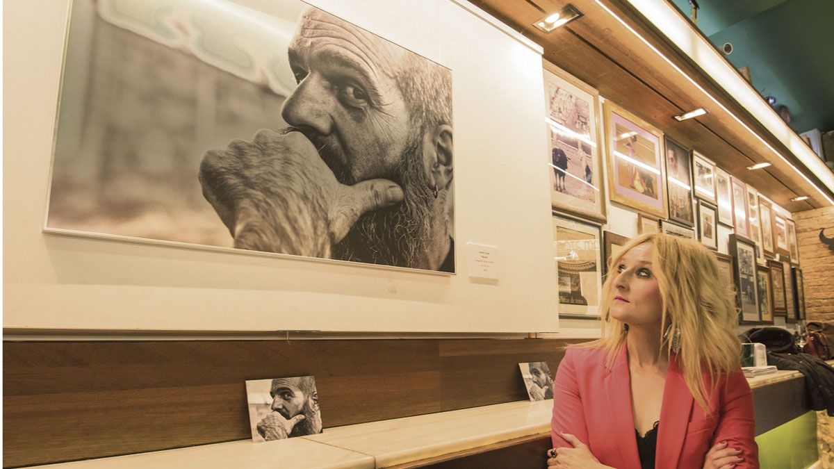 Carmen Coque contempla el retrato de su amigo Manuel Alonso que se expone desde este miércoles en el Camarote Madrid. | SAÚL ARÉN