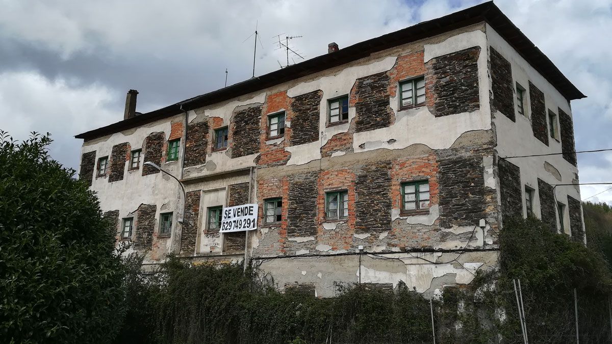 El cartel de ‘Se vende’ luce sobre la fachada del viejo cuartel de Vega de Espinareda.| D.M.