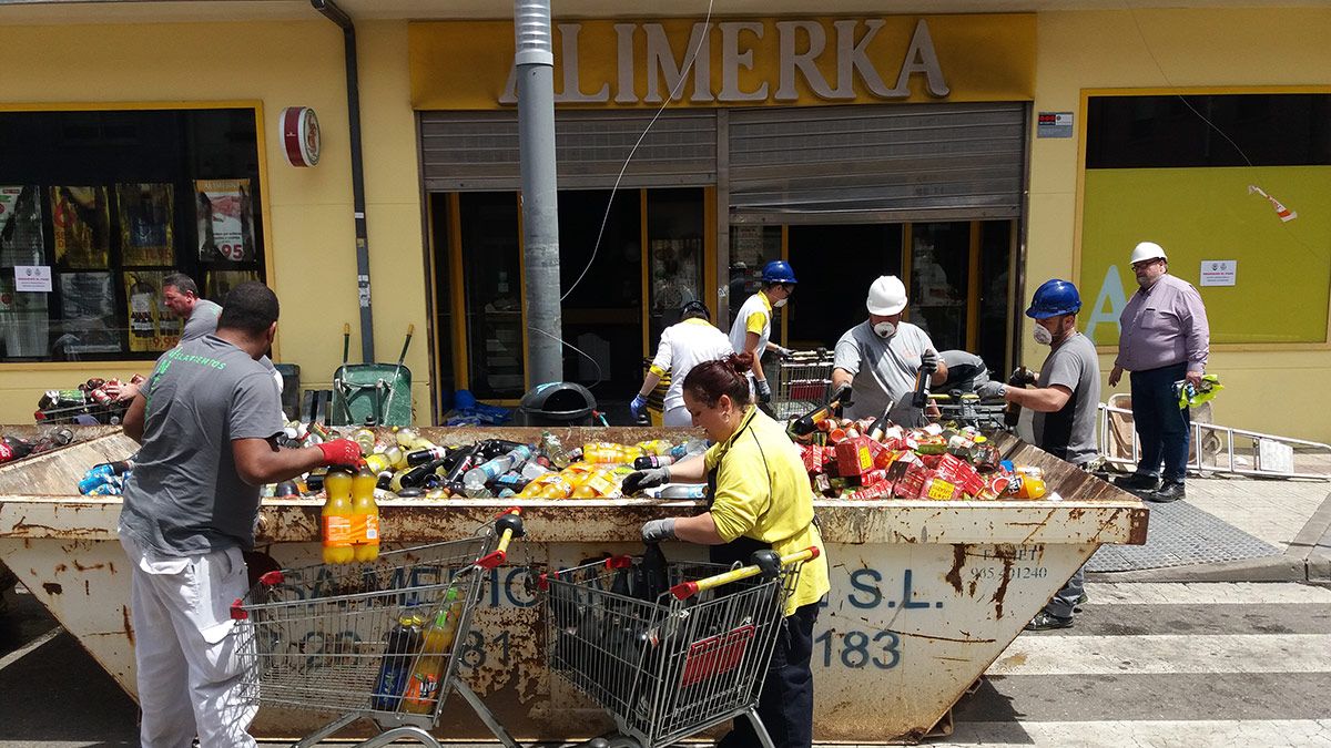 Trabajadores del supermercado sacando los productos afectados por el incendio. | MAURICIO PEÑA Trabajadores del supermercado sacando los productos afectados por el incendio. | MAURICIO PEÑA