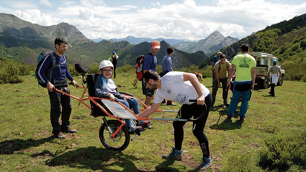 Álvaro ya está subido a su silla Jöelette adaptada para iniciar la ruta, los voluntarios hacen los últimos ajustes y a caminar. | CLUB PANDETRAVE